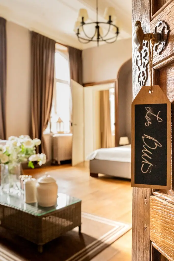 Suite du château avec lustre, lit et ardoise nominative à l'entrée