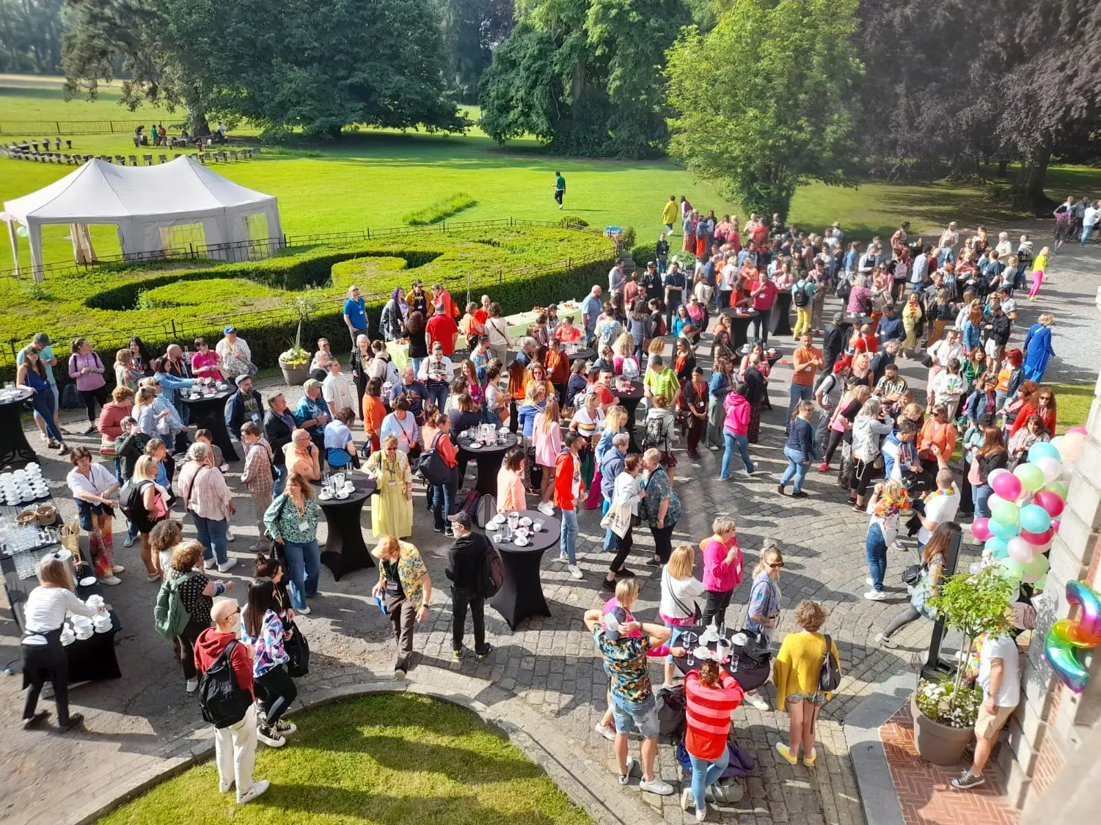 Nombreux visiteurs lors d'une fête de jardin, tentes et ballons dans le parc